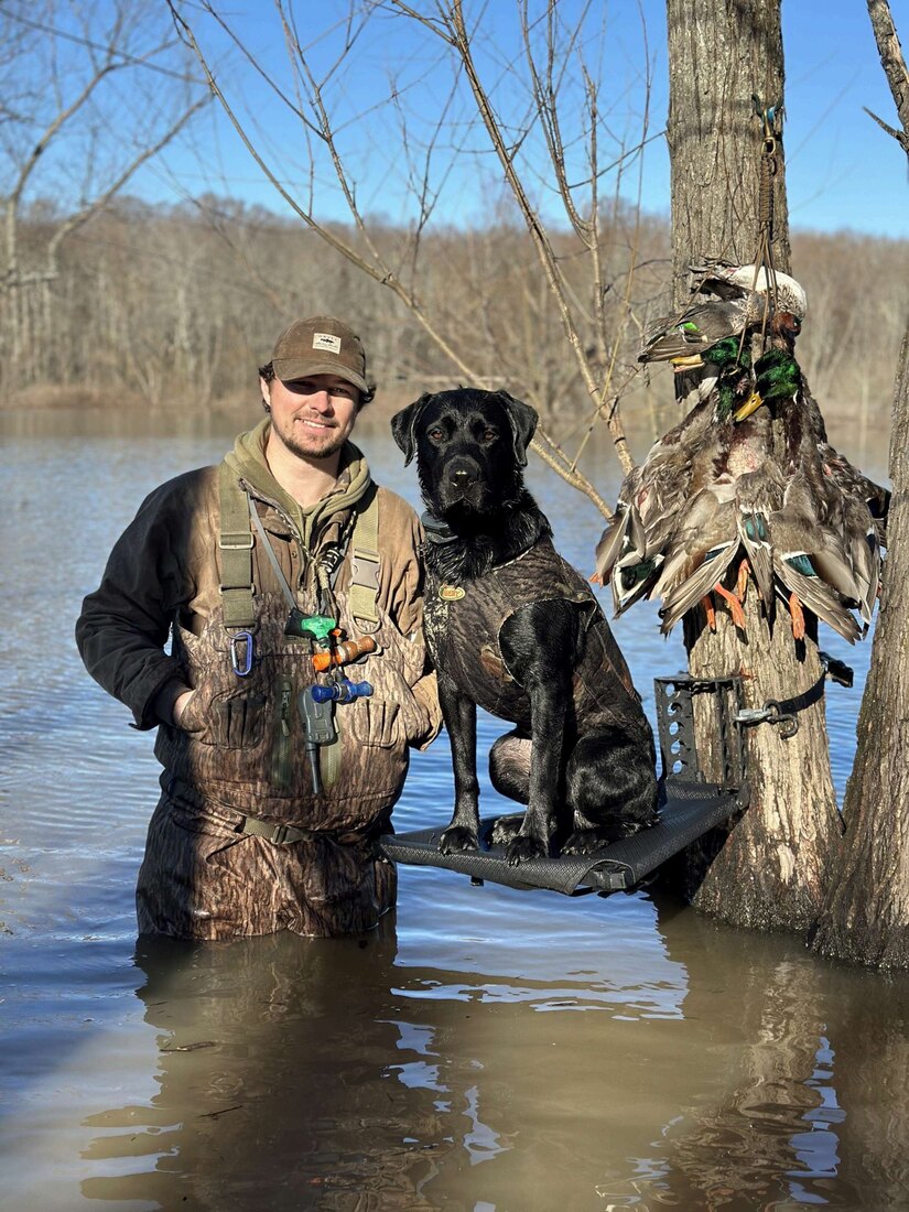 Payton with his retriever on the water